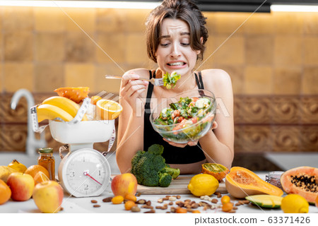 Sports woman with healthy food on the kitchen Sports woman with healthy food on the kitchen 63371426
