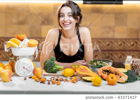 Sports woman with healthy food on the kitchen Sports woman with healthy food on the kitchen 63371437