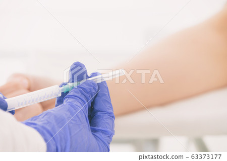Doctor's hands holding a ready-to-use syringe Doctor's hands holding a ready-to-use syringe 63373177