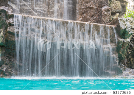 landscape of beautiful Artificial waterfall in garden at the public park. 63373686