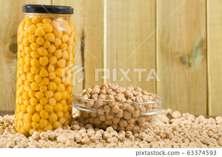 Glass bowl of raw chickpeas on wooden surface. Healthy and nutritious food Glass bowl of raw chickpeas on wooden surface. Healthy and nutritious food 63374593