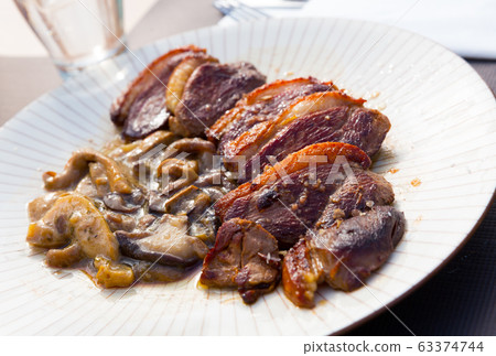 Fried duck breast Magre served with mushrooms Fried duck breast Magre served with mushrooms 63374744