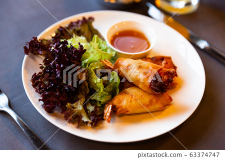 Fried spring rolls with vegetables and shrimps with sauce and salad Fried spring rolls with vegetables and shrimps with sauce and salad 63374747