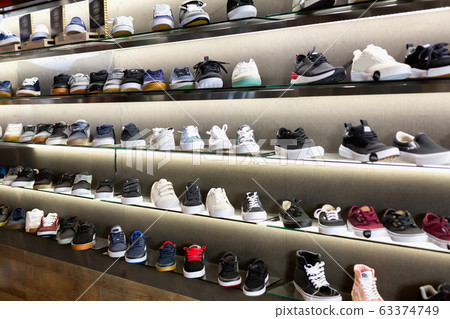 Variety of men and unisex sneakers in modern shoe shop Variety of men and unisex sneakers in modern shoe shop 63374749