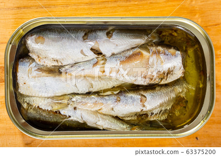 Tin can with smoked sprats, sardines, closeup Tin can with smoked sprats, sardines, closeup 63375200