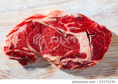 Raw veal steak with herbs 63375230