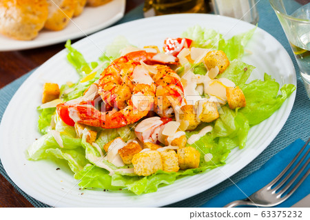 Caesar salad with prawns, lettuce, sauce and cheese 63375232
