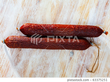 Close-up of smoked russian sausage at wooden surface 63375251
