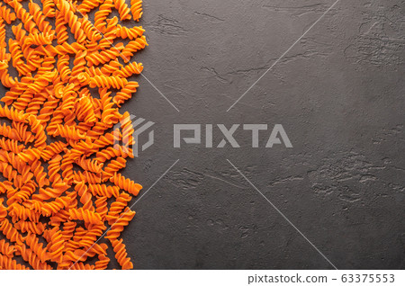 Orange pasta background concept on dark background. Diet and healthy food concept. Italian cuisine 63375553