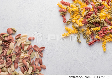 Multicolored shells macaroni background concept. Diet and healthy food concept. Italian cuisine Multicolored shells macaroni background concept. Diet and healthy food concept. Italian cuisine 63375563
