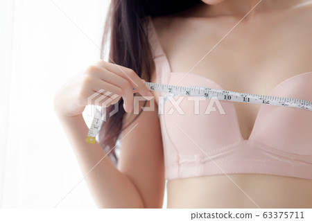 Closeup beautiful young asian woman sexy body slim measuring breast for control weight loss 63375711