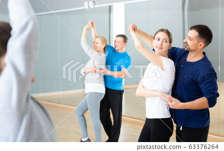 Young couple practicing active dance in pair Young couple practicing active dance in pair 63376264