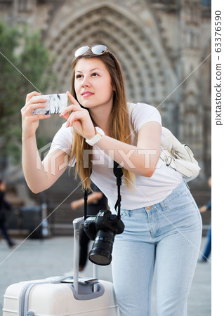 Girl holding phone and photographing Girl holding phone and photographing 63376590