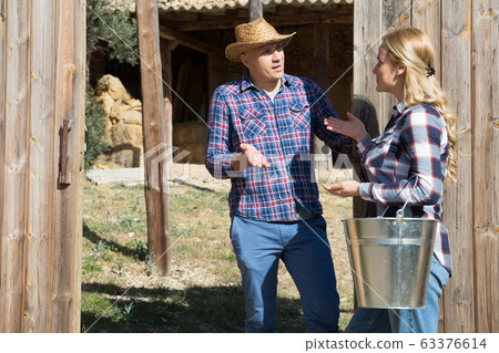 Neighbors have a conversation near the village house Neighbors have a conversation near the village house 63376614