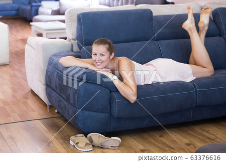 Adult female customer lying in the furniture store 63376616