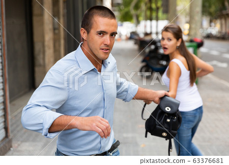 Thief stealing woman bag 63376681