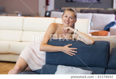woman buyer sitting on sofa with pillow woman buyer sitting on sofa with pillow 63376692