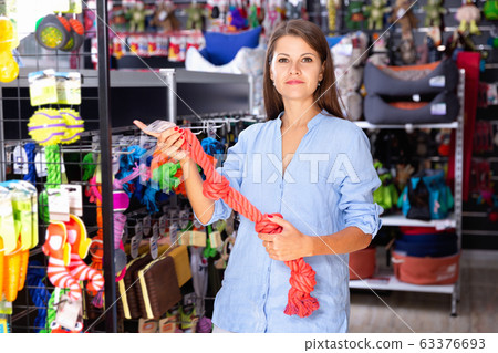Portrait of positive girl buying pet supplies in modern petshop Portrait of positive girl buying pet supplies in modern petshop 63376693