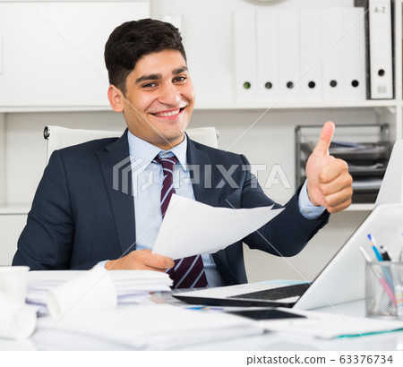 Smiling manager reading documents about the transaction Smiling manager reading documents about the transaction 63376734