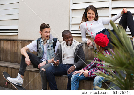 Group of teenage friends relaxing and chatting 63376744