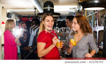 Two young women with cocktails having fun on party at nightclub Two young women with cocktails having fun on party at nightclub 63376747