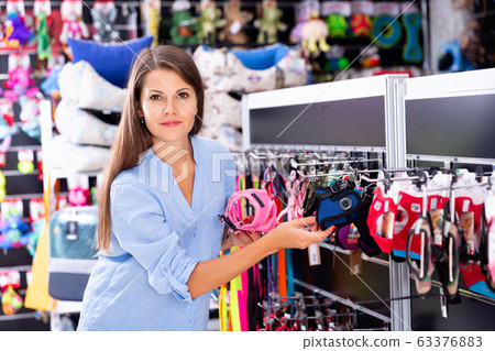 Portrait of positive girl buying pet supplies in modern petshop Portrait of positive girl buying pet supplies in modern petshop 63376883