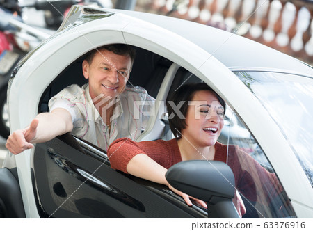 Couple standing near twizy electric 63376916