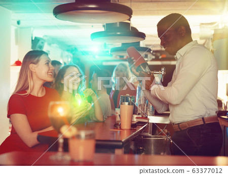 Young women drink cocktails at the bar in nightclub Young women drink cocktails at the bar in nightclub 63377012