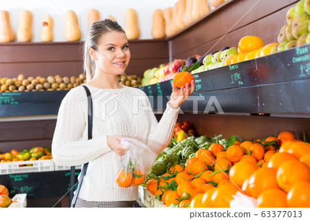Girl choosing fruits in grocery Girl choosing fruits in grocery 63377013