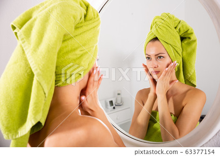 Female looking in mirror at home 63377154