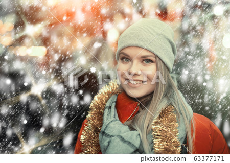 Girl choosing Christmas gifts outdoor on street market Girl choosing Christmas gifts outdoor on street market 63377171