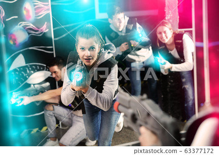 Smiling girl with laser guns took aim and having fun with friends Smiling girl with laser guns took aim and having fun with friends 63377172