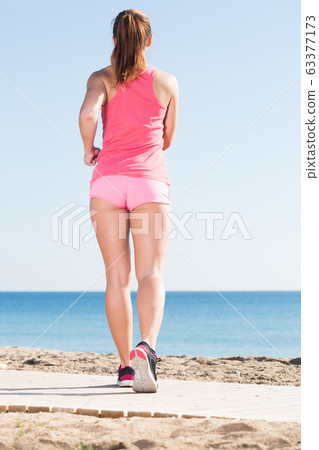 young girl jogging at seaside 63377173