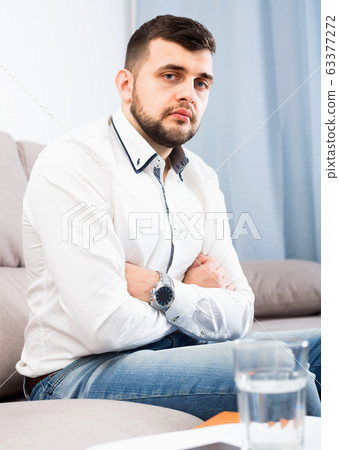 Man feeling distressed and lonely alone at home 63377272
