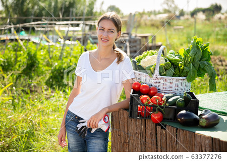 Portrait of young woman gardener with harvest of vegetables 63377276