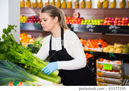 Salesgirl arranging greens Salesgirl arranging greens 63377295