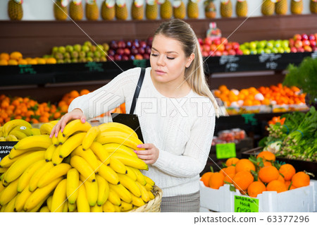 Young female choosing fresh bananas on the supermarket Young female choosing fresh bananas on the supermarket 63377296