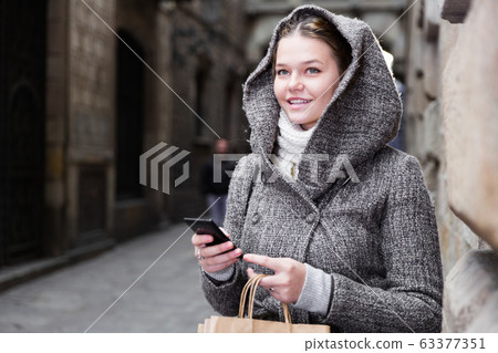 girl using mobile phone at the street girl using mobile phone at the street 63377351