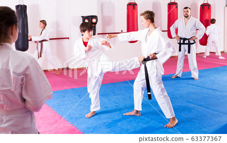 Children working in pair mastering new karate moves Children working in pair mastering new karate moves 63377367