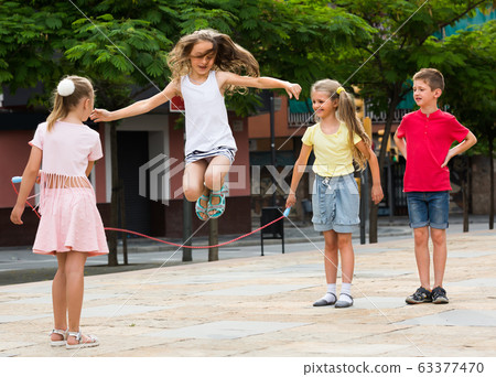 children with jumping rope at playground. children with jumping rope at playground. 63377470
