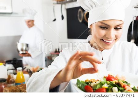 Female chef preparing fresh salad 63377471