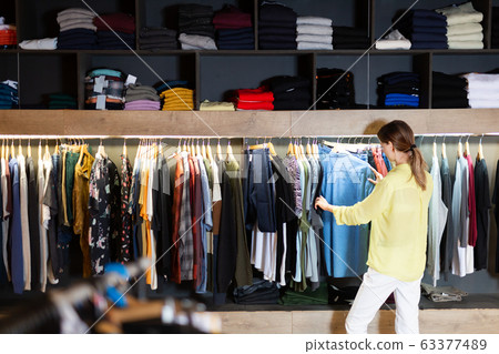 Young woman shopping casual clothes in men store Young woman shopping casual clothes in men store 63377489