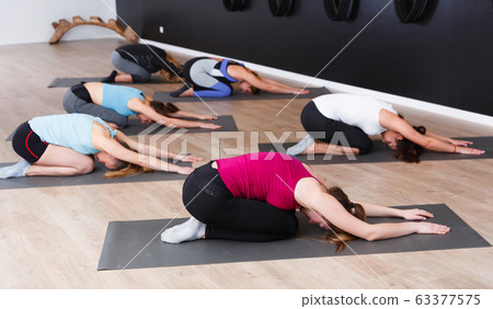Girls practicing yoga positions indoors Girls practicing yoga positions indoors 63377575
