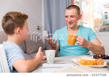 Man with his son are talking about life together in time lunch Man with his son are talking about life together in time lunch 63377590