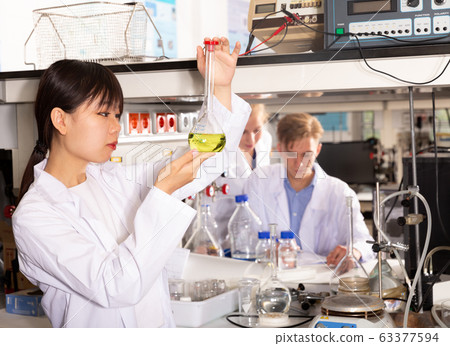 Female Chinese chemist analyzing liquid 63377594
