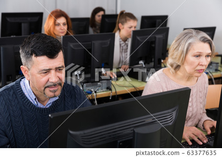 Middle aged man taking computer lessons 63377635