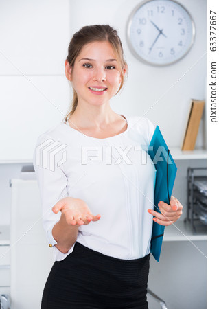 Businesswoman with clipboard welcoming to office Businesswoman with clipboard welcoming to office 63377667