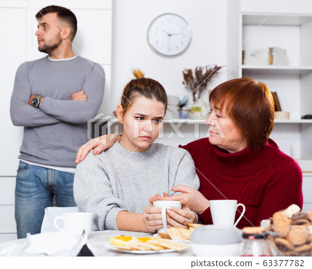 Woman calming girl during quarrel with boyfriend 63377782