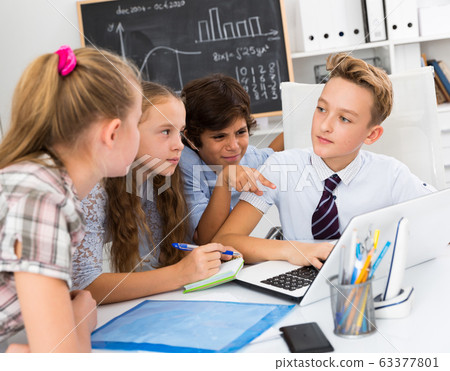 Boys and girls talking near the notebook 63377801