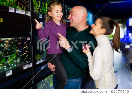 Happy family choosing aquarium fish 63377940